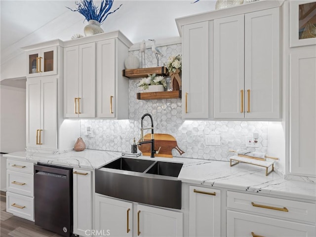 kitchen featuring a sink, white cabinetry, light stone countertops, open shelves, and glass insert cabinets