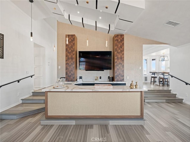 unfurnished living room featuring baseboards, visible vents, vaulted ceiling, and light wood finished floors