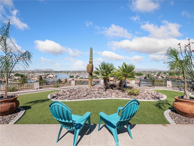 view of community featuring a water view, fence, and a yard