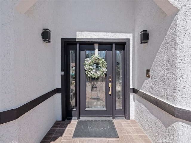 doorway to property featuring stucco siding