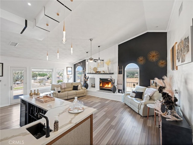 living room with wine cooler, a fireplace, visible vents, and a healthy amount of sunlight