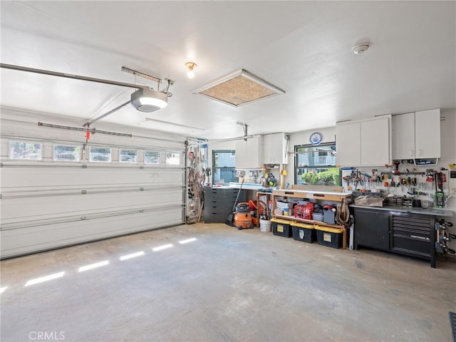 garage with a workshop area and a garage door opener