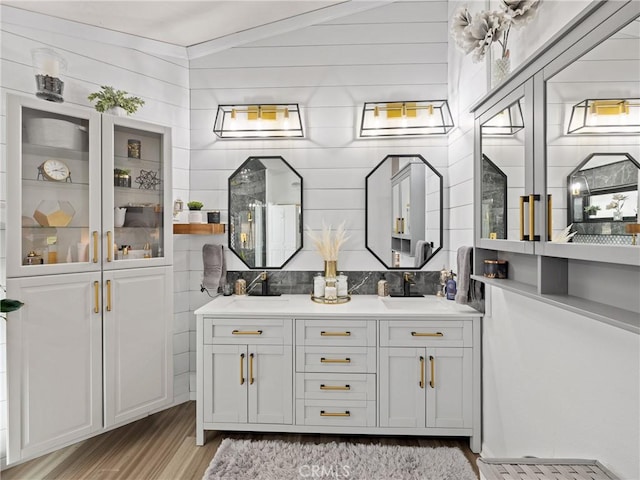 bathroom featuring double vanity, backsplash, and a sink