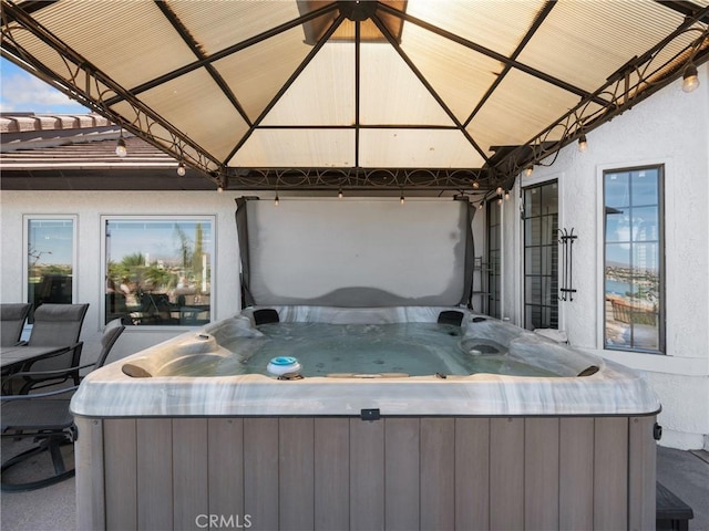 view of patio / terrace featuring a hot tub and a gazebo