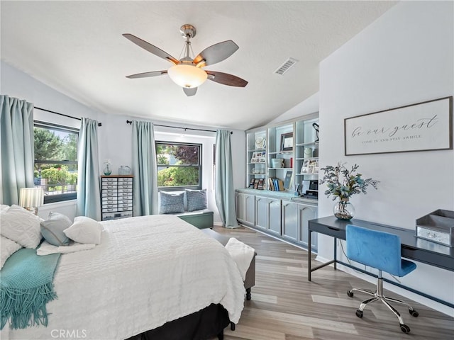 bedroom featuring visible vents, vaulted ceiling, and multiple windows