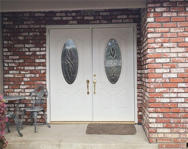 entrance to property featuring brick siding