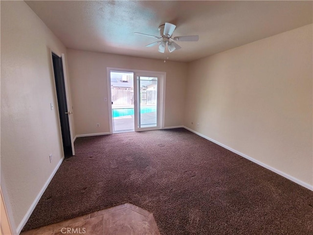 spare room featuring carpet floors, ceiling fan, and baseboards