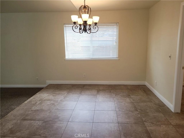 tiled empty room with a notable chandelier and baseboards