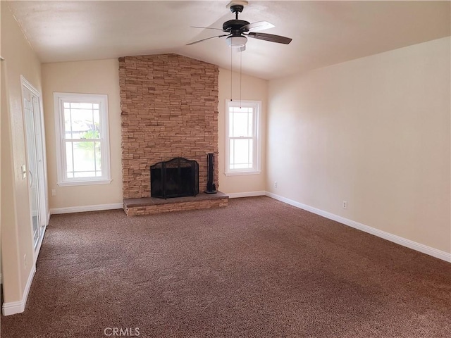 unfurnished living room featuring dark carpet, a wealth of natural light, a fireplace, and lofted ceiling