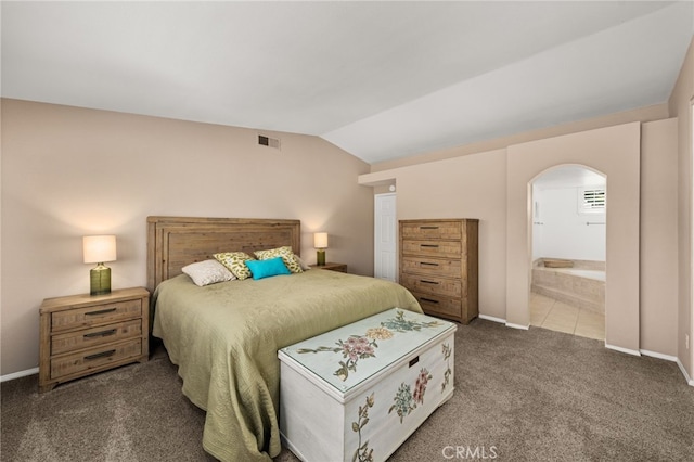 bedroom with vaulted ceiling, carpet, and ensuite bathroom