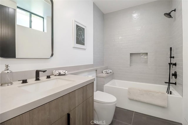 full bathroom featuring vanity, tile patterned flooring, toilet, and tiled shower / bath