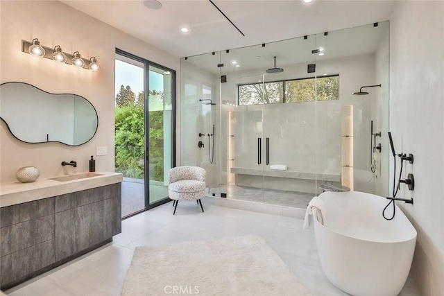 bathroom with vanity, shower with separate bathtub, and a healthy amount of sunlight