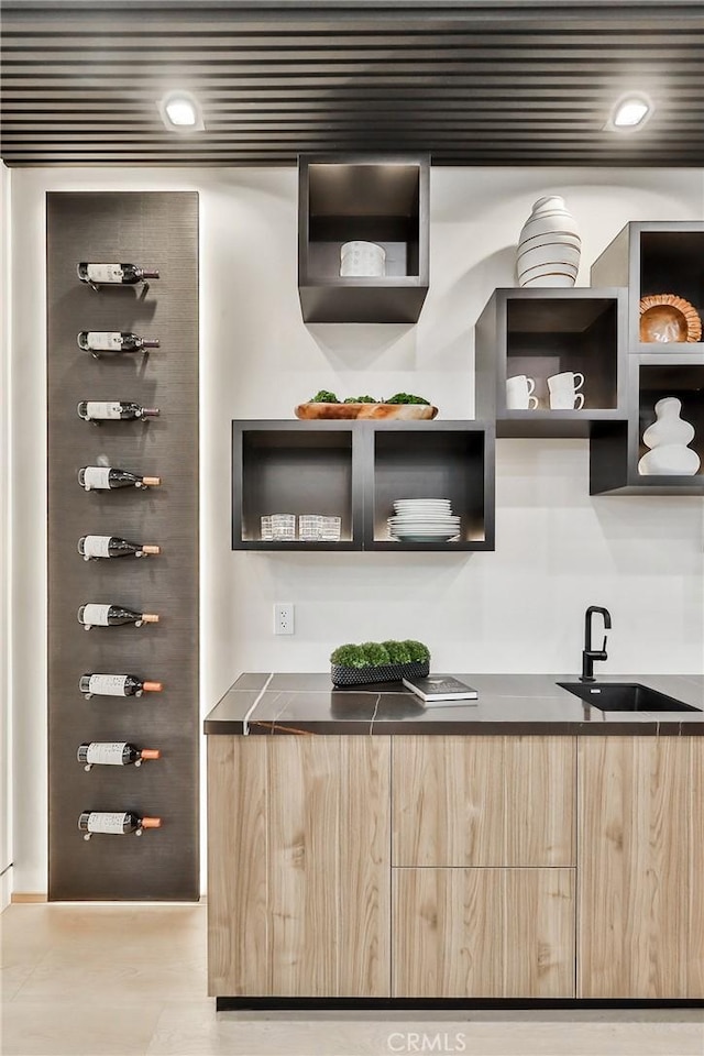 bar with sink and light brown cabinets