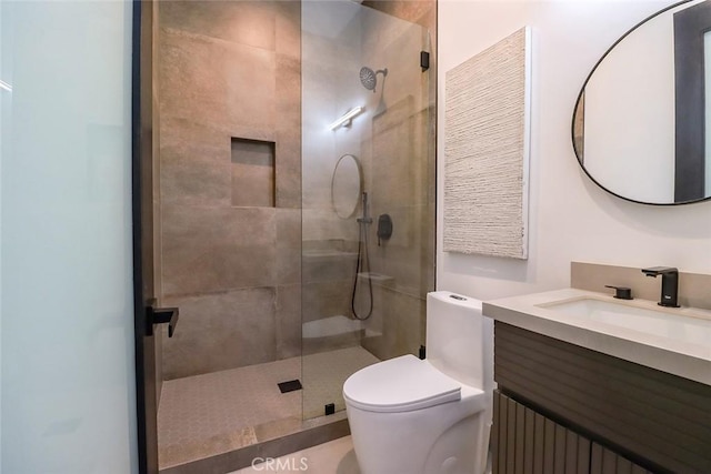 bathroom with vanity, toilet, and tiled shower