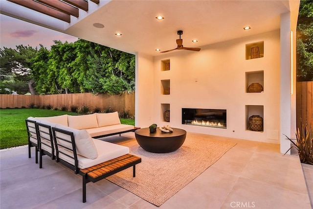 patio terrace at dusk with outdoor lounge area and ceiling fan