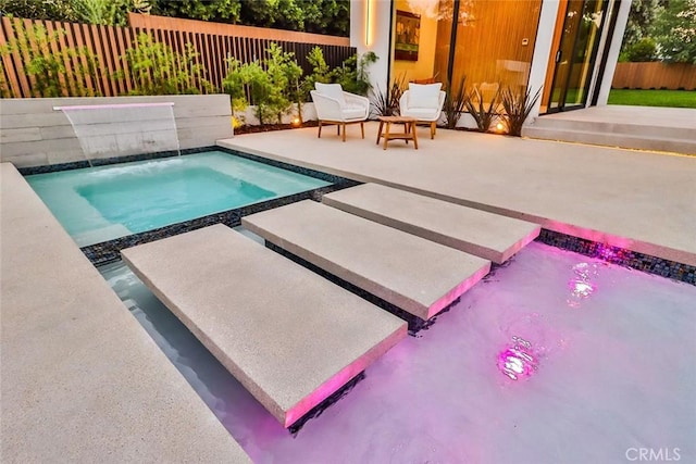 view of swimming pool with a patio and pool water feature