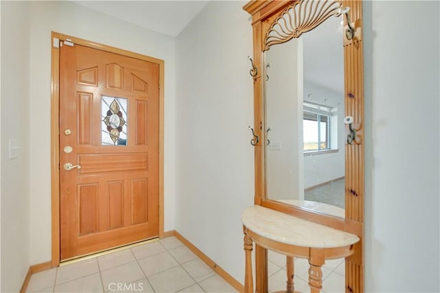 foyer entrance with light tile patterned floors and baseboards