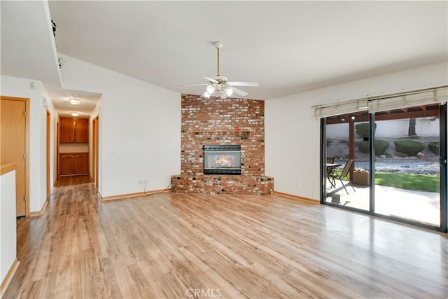 unfurnished living room featuring light wood finished floors, a fireplace, a ceiling fan, and baseboards