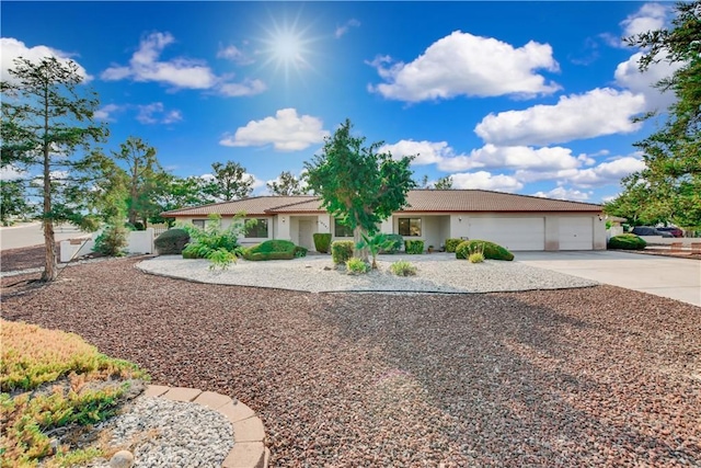 ranch-style home with driveway, an attached garage, and stucco siding