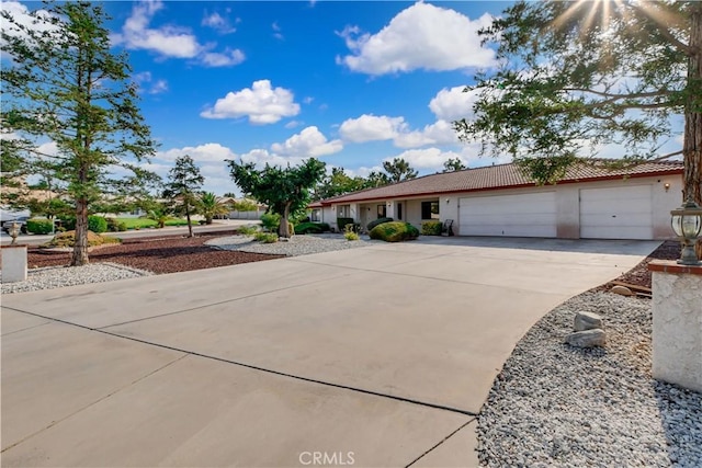 single story home with driveway, a tiled roof, an attached garage, and stucco siding