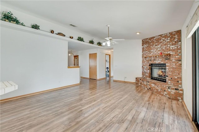 unfurnished living room with a fireplace, visible vents, a ceiling fan, light wood-type flooring, and baseboards