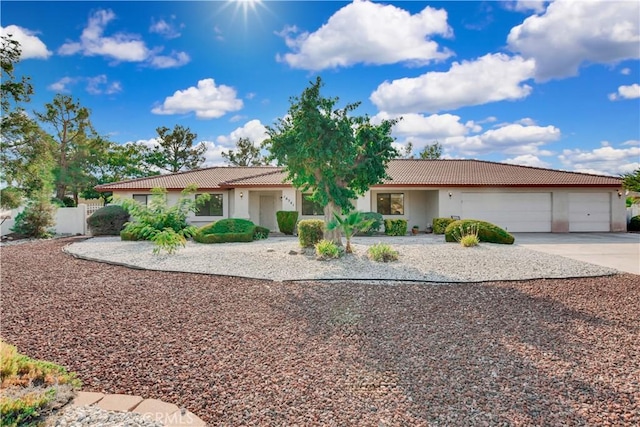 ranch-style home featuring a garage, driveway, a tile roof, and stucco siding