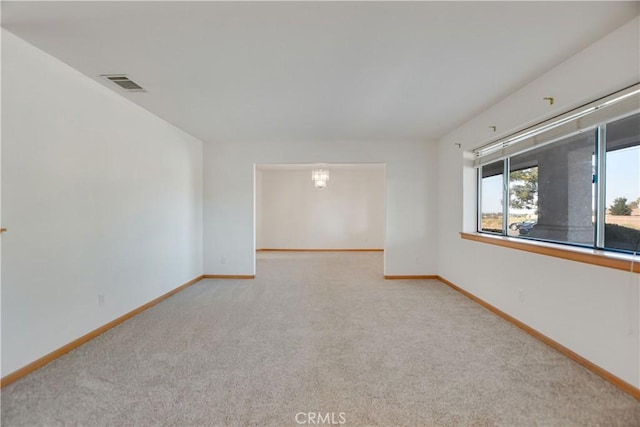 empty room with baseboards, visible vents, and carpet flooring