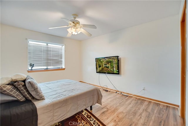 bedroom with a ceiling fan, baseboards, and wood finished floors