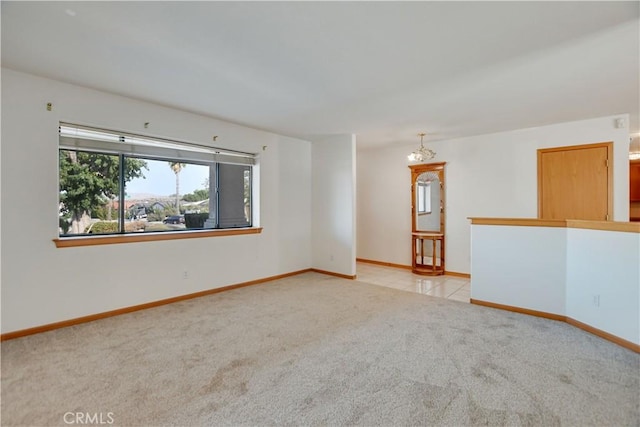 empty room featuring light carpet and baseboards