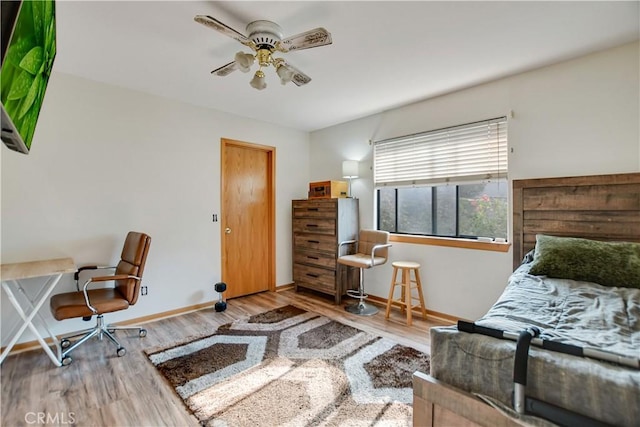 bedroom featuring ceiling fan, baseboards, and wood finished floors