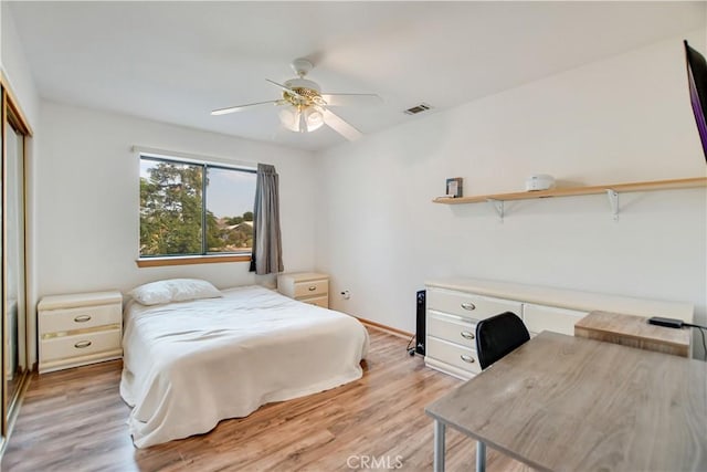 bedroom with light wood finished floors, ceiling fan, visible vents, and a closet