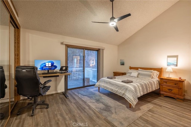 bedroom with lofted ceiling, access to exterior, hardwood / wood-style floors, and a textured ceiling