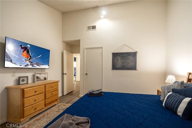 bedroom featuring a high ceiling and hardwood / wood-style floors