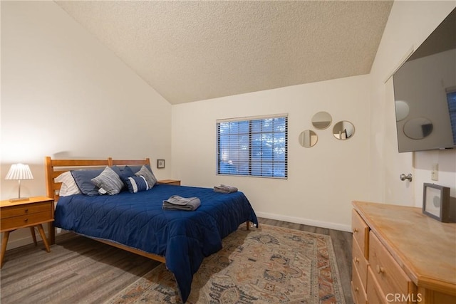 bedroom featuring hardwood / wood-style floors, vaulted ceiling, and a textured ceiling