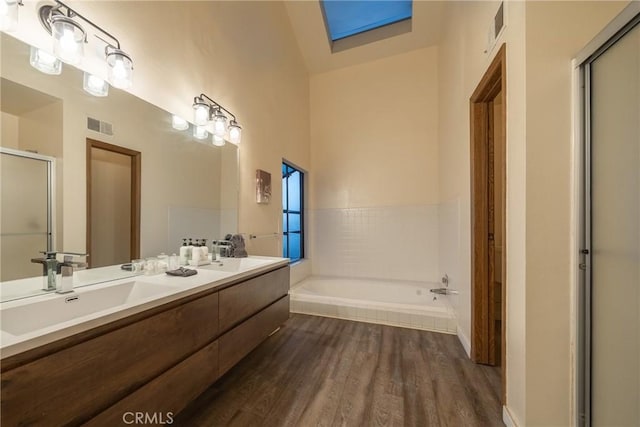 bathroom with wood-type flooring, separate shower and tub, and vanity