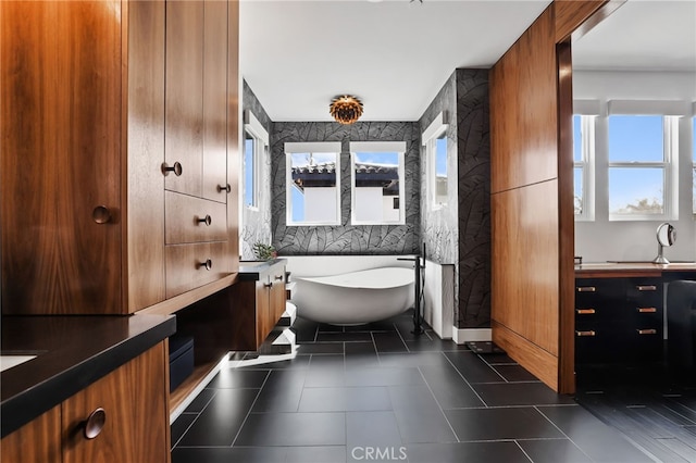 bathroom featuring vanity, a bath, and tile patterned floors