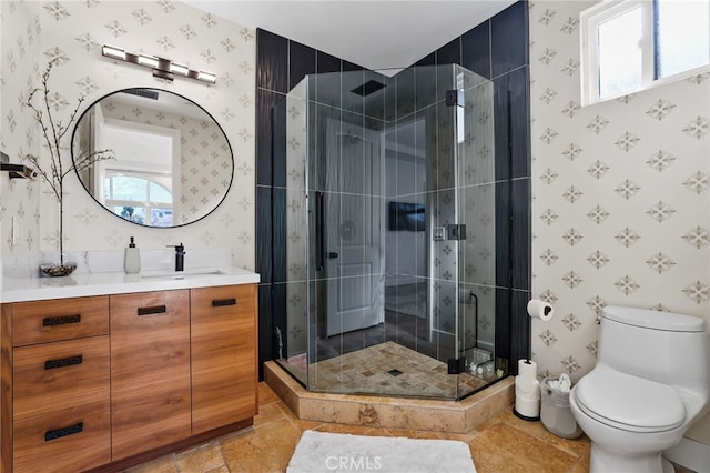 bathroom featuring vanity, toilet, and a shower with door