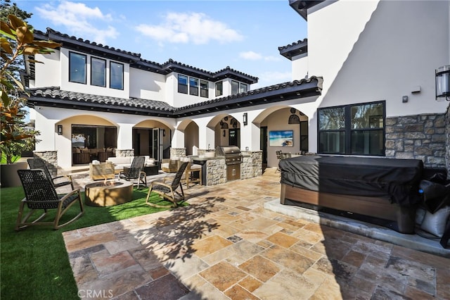 view of patio with a grill, area for grilling, and an outdoor living space with a fire pit