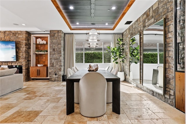 dining area featuring a wealth of natural light, a notable chandelier, a fireplace, and a tray ceiling