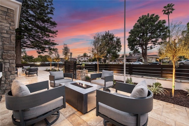 patio terrace at dusk featuring an outdoor living space with a fire pit