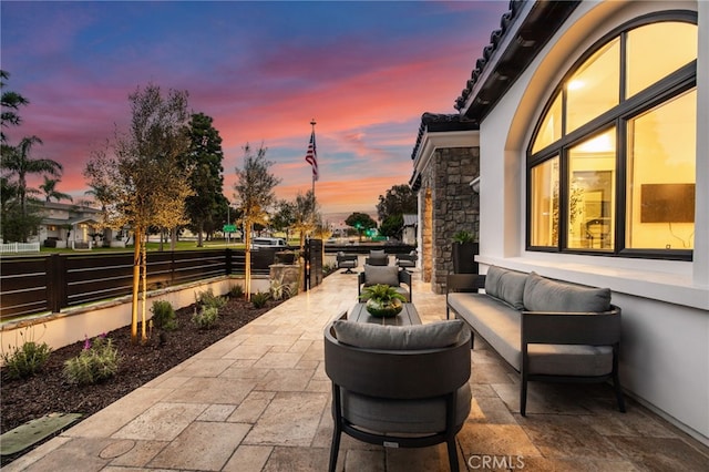 patio terrace at dusk featuring an outdoor hangout area