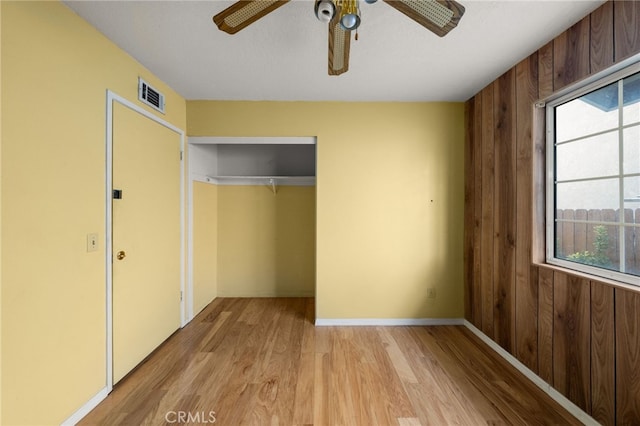 unfurnished bedroom featuring light wood finished floors, multiple windows, a closet, and visible vents