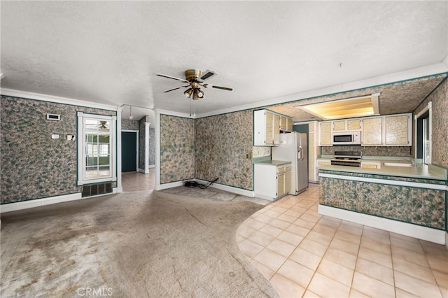 interior space featuring wallpapered walls, range, white microwave, fridge with ice dispenser, and light countertops