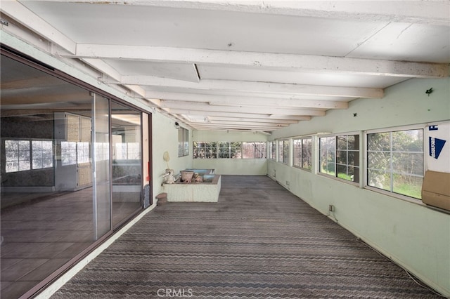 unfurnished sunroom featuring plenty of natural light and lofted ceiling with beams