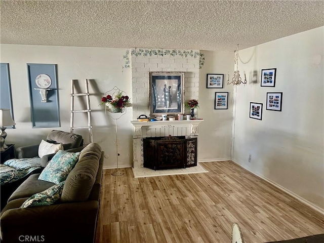 living room featuring a textured ceiling, a fireplace, and wood-type flooring