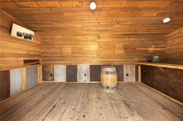 interior space featuring hardwood / wood-style floors, wood ceiling, vaulted ceiling, and wooden walls