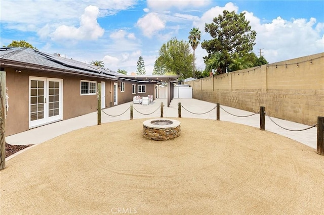 view of patio with french doors and a fire pit