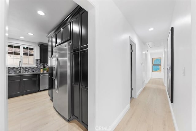 kitchen featuring sink, backsplash, stainless steel appliances, and light hardwood / wood-style floors