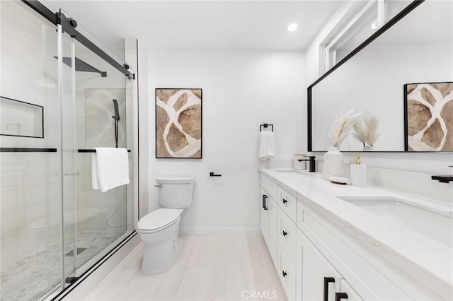 bathroom featuring vanity, toilet, and an enclosed shower