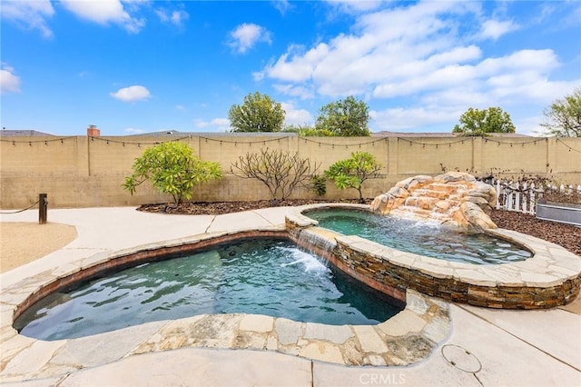 view of pool featuring pool water feature and an in ground hot tub